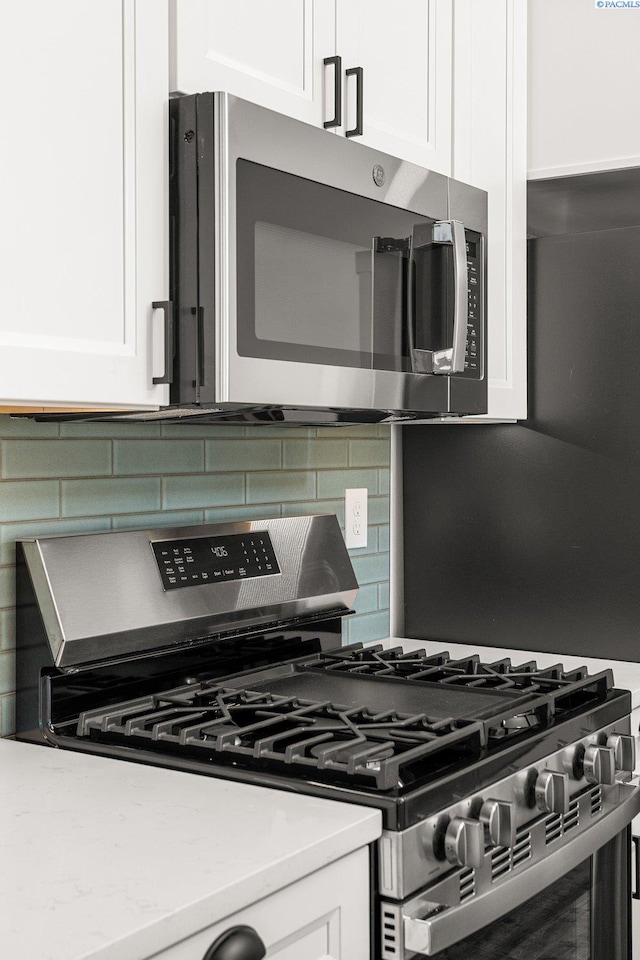 kitchen featuring white cabinetry, appliances with stainless steel finishes, and backsplash