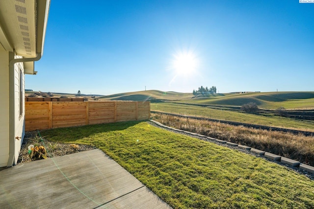 view of yard with a rural view and a patio area