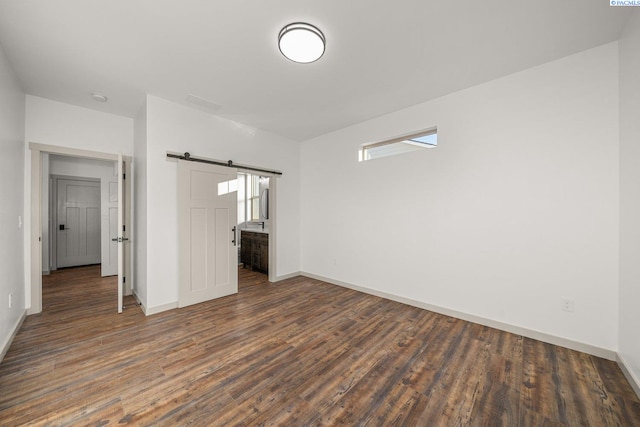 interior space featuring dark wood-type flooring and a barn door