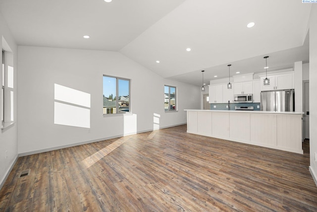 unfurnished living room featuring dark hardwood / wood-style flooring, sink, and vaulted ceiling