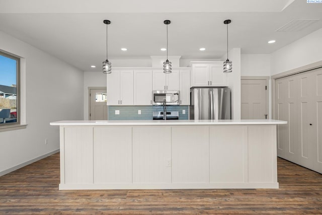 kitchen featuring white cabinetry, an island with sink, appliances with stainless steel finishes, and pendant lighting