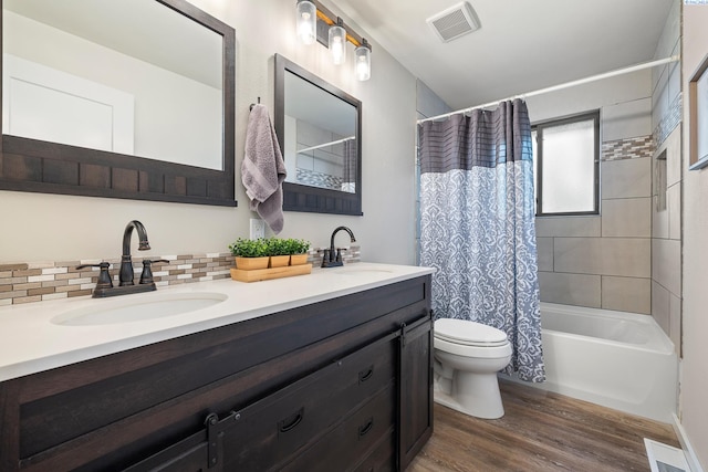 1830 W 23rd Ave, Kennewick, WA 99337 - full bathroom featuring wood finished floors, toilet, double vanity, shower / bath combo, and decorative backsplash