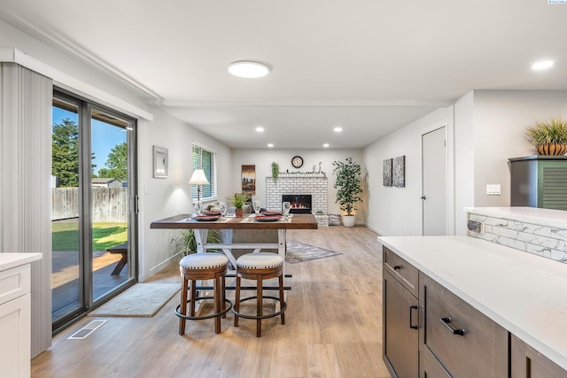 1830 W 23rd Ave, Kennewick, WA 99337 - kitchen featuring light wood-type flooring, baseboards, light countertops, a brick fireplace, and recessed lighting
