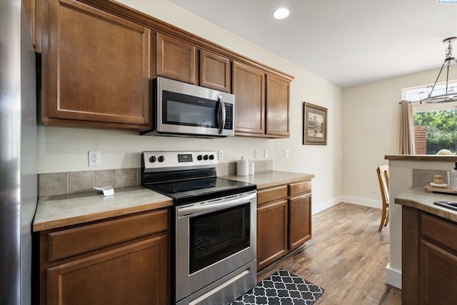 5719 W 15th Ave, Kennewick, WA 99338 - kitchen with stainless steel appliances, light countertops, wood finished floors, pendant lighting, and recessed lighting