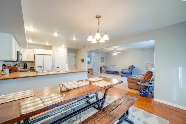 dining area with sink, light hardwood / wood-style flooring, and ceiling fan