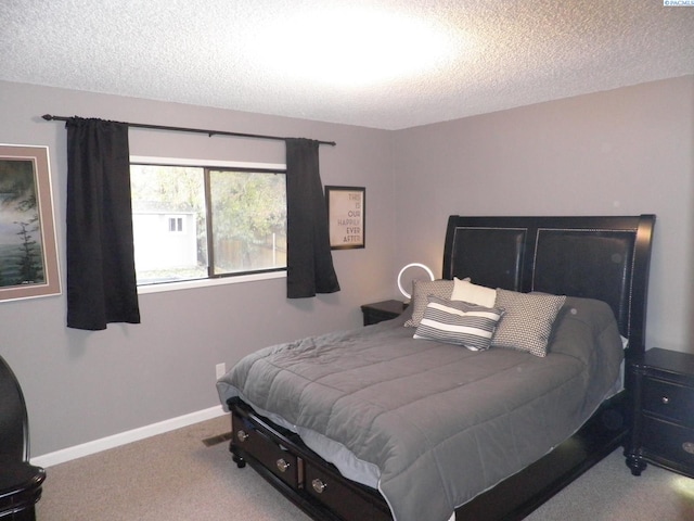 bedroom featuring light carpet and a textured ceiling