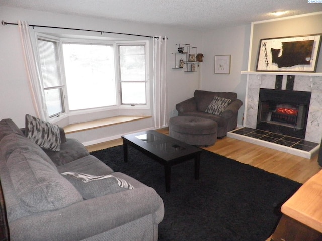 living room featuring hardwood / wood-style flooring, a textured ceiling, and a fireplace