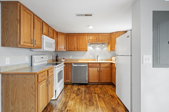 kitchen featuring white appliances, electric panel, brown cabinetry, dark wood-style flooring, and a sink