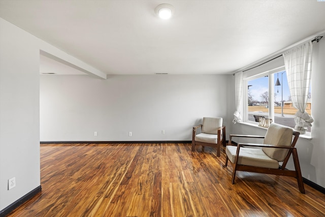 living area featuring baseboards and wood finished floors