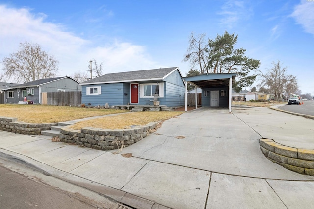 view of front of house featuring concrete driveway, a front yard, and fence