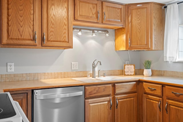 kitchen featuring stove, brown cabinets, light countertops, stainless steel dishwasher, and a sink