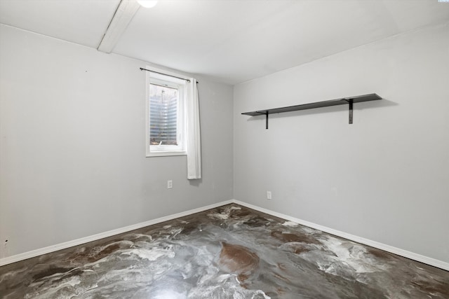 empty room with baseboards and unfinished concrete floors