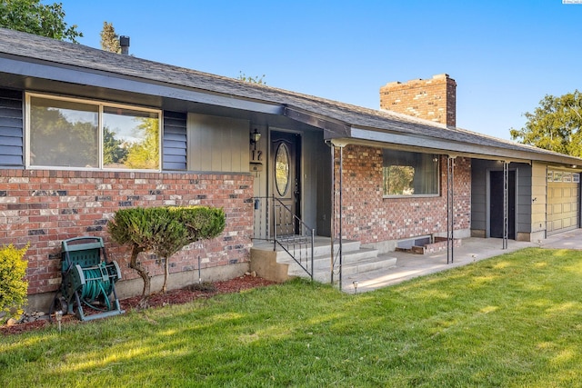 1112 Mcmurray St, Richland, WA 99354 - view of exterior entry with brick siding, a lawn, and a chimney