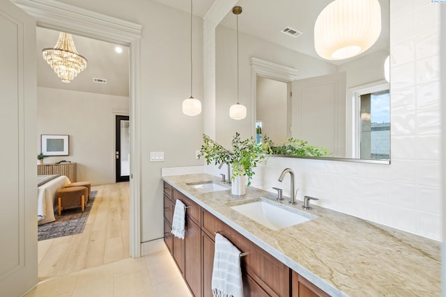 bathroom featuring vanity, tile patterned flooring, and an inviting chandelier