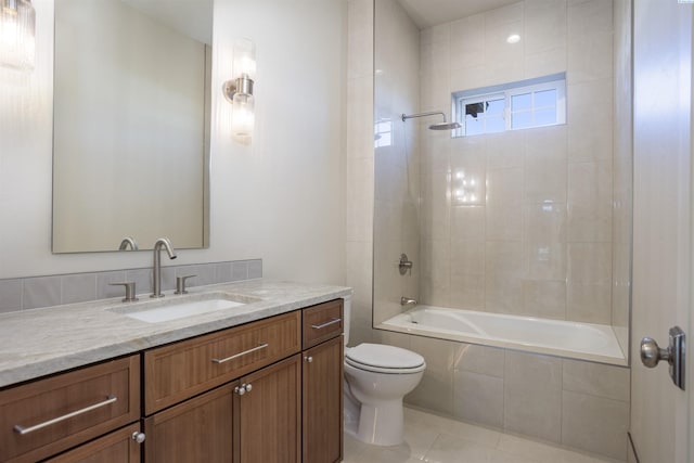 full bathroom with tiled shower / bath, vanity, toilet, and tile patterned floors