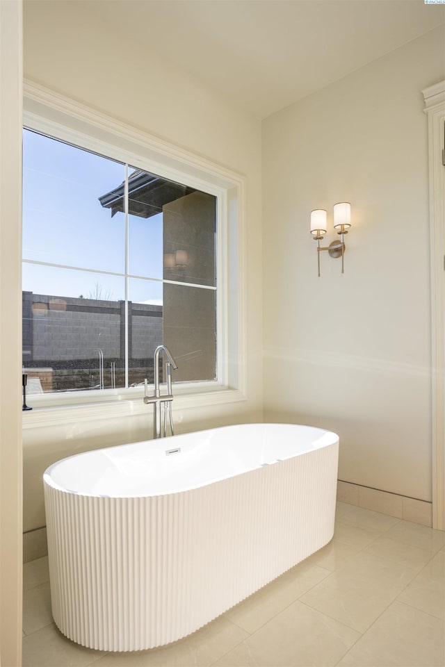 bathroom with tile patterned flooring and a tub to relax in