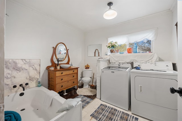 laundry room with light tile patterned flooring, independent washer and dryer, crown molding, and laundry area