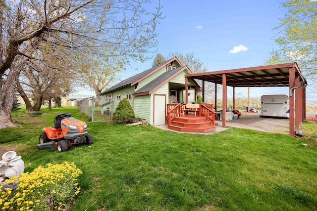 exterior space featuring fence, an outdoor structure, and a yard