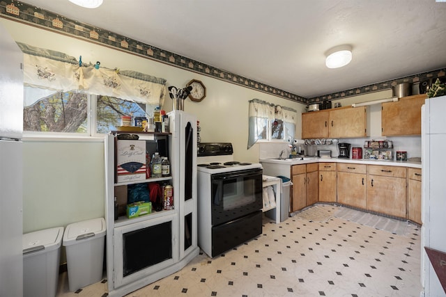 kitchen with light floors, electric stove, plenty of natural light, and light countertops