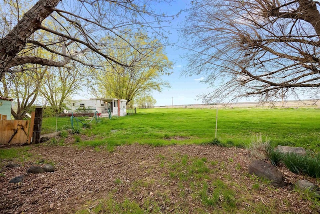 view of yard with a rural view and fence