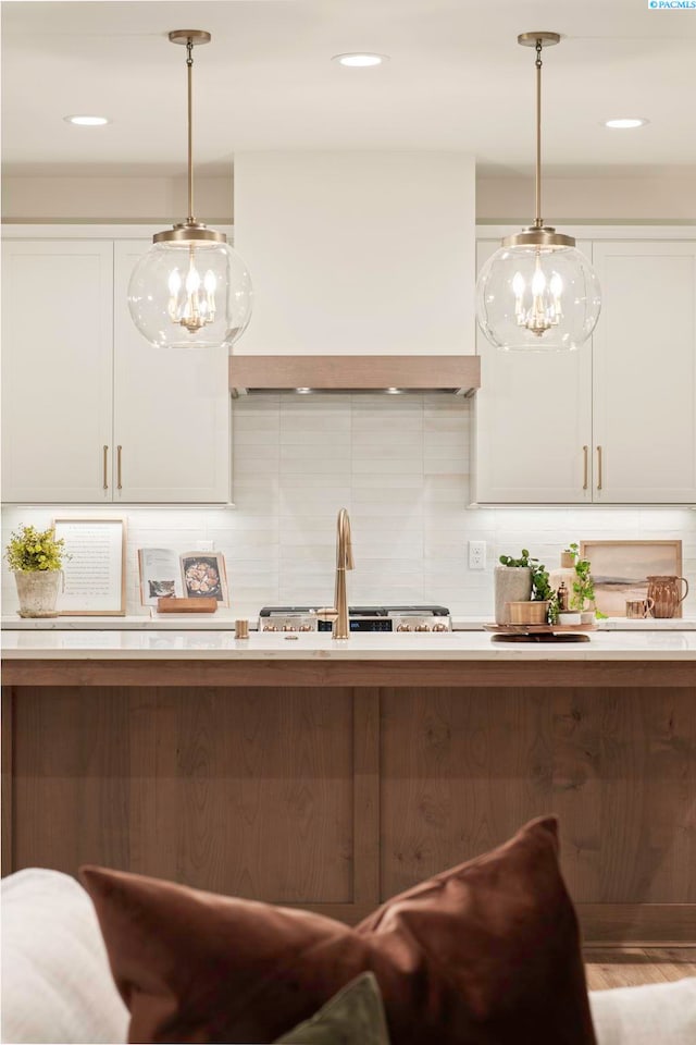 kitchen with custom exhaust hood, tasteful backsplash, and pendant lighting