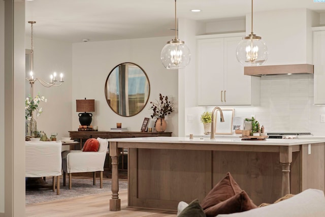 bar with decorative light fixtures, custom exhaust hood, decorative backsplash, and light wood-type flooring