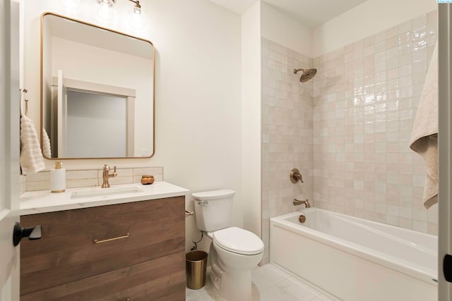 full bathroom featuring tiled shower / bath, vanity, and toilet