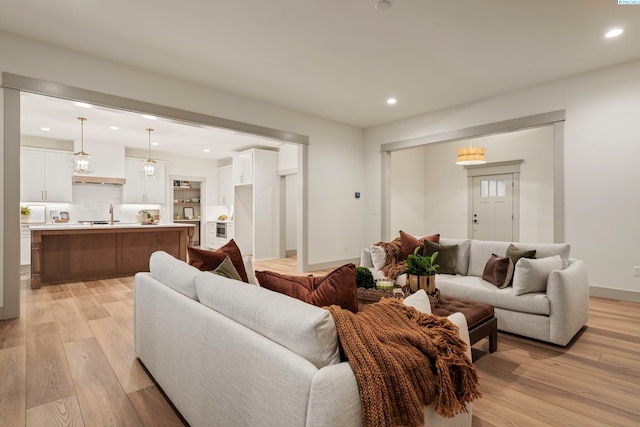 living room featuring sink and light hardwood / wood-style floors