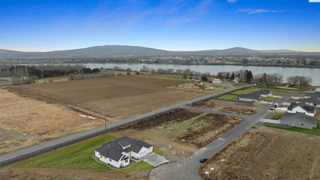 drone / aerial view featuring a water and mountain view