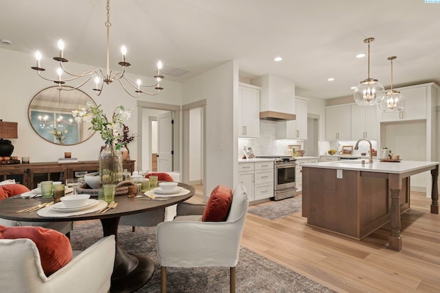 dining space with sink and light hardwood / wood-style flooring