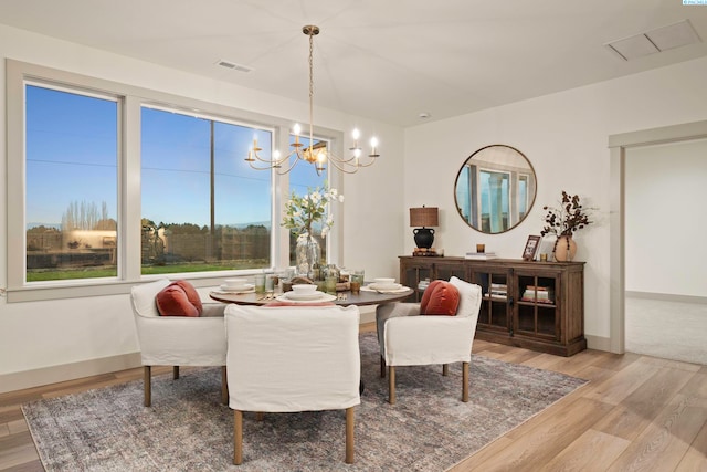 dining room featuring an inviting chandelier and light wood-type flooring