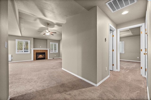 corridor with light colored carpet and a textured ceiling