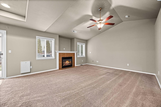 unfurnished living room featuring lofted ceiling, a healthy amount of sunlight, and carpet floors