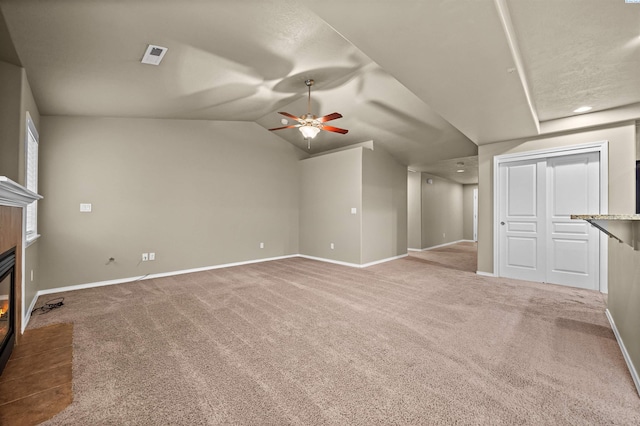 unfurnished living room featuring vaulted ceiling, ceiling fan, and carpet floors