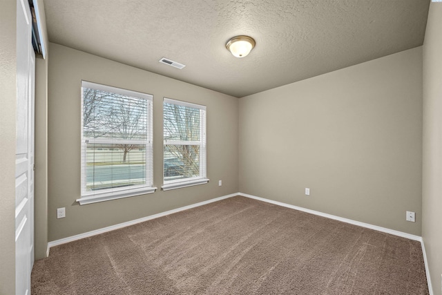 unfurnished room featuring carpet floors and a textured ceiling