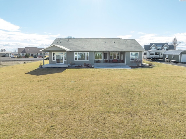 rear view of property featuring a yard and a patio area