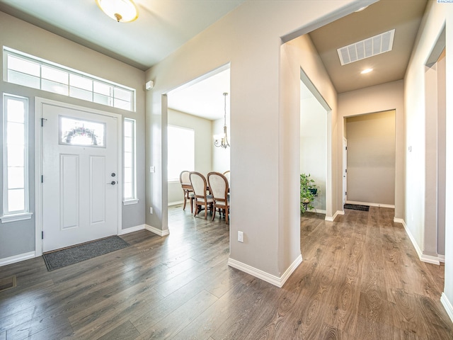 entrance foyer with a healthy amount of sunlight, baseboards, visible vents, and dark wood finished floors