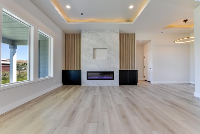 1557 Livorno Ave, Richland, WA 99352 - unfurnished living room with a fireplace, light wood finished floors, a tray ceiling, and baseboards
