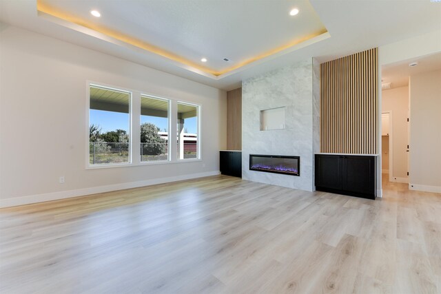 1557 Livorno Ave, Richland, WA 99352 - unfurnished living room with baseboards, a raised ceiling, a fireplace, and light wood finished floors