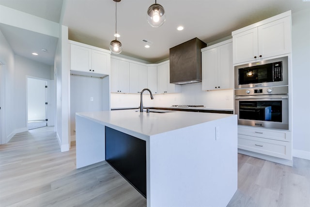 1557 Livorno Ave, Richland, WA 99352 - kitchen featuring light wood-style floors, wall chimney exhaust hood, white cabinetry, appliances with stainless steel finishes, and a sink