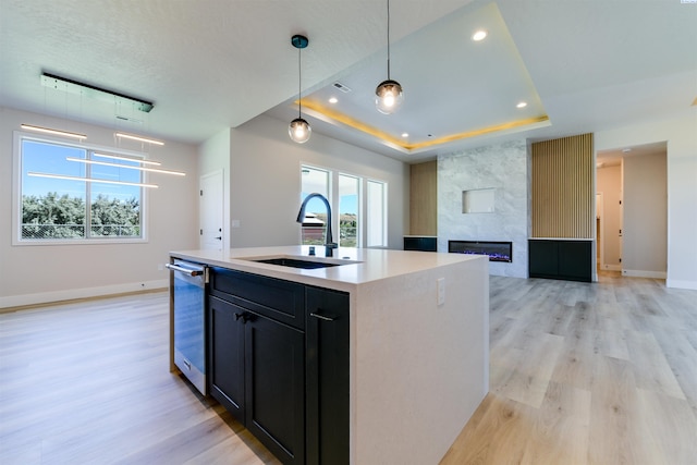 1557 Livorno Ave, Richland, WA 99352 - kitchen with baseboards, light wood-style flooring, a raised ceiling, a sink, and hanging light fixtures