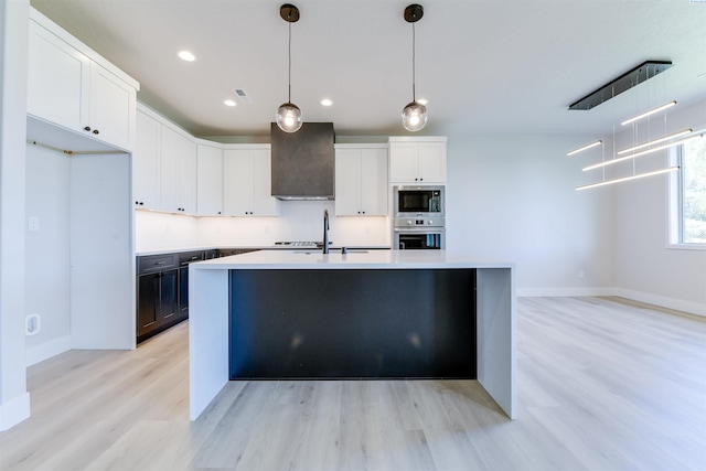 1557 Livorno Ave, Richland, WA 99352 - kitchen featuring wall chimney range hood, stainless steel appliances, light countertops, and white cabinetry