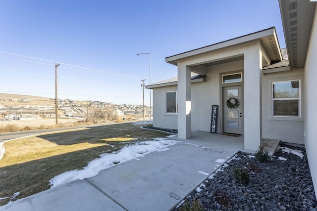 view of exterior entry with a yard