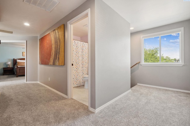 hall featuring carpet floors, recessed lighting, baseboards, and an upstairs landing