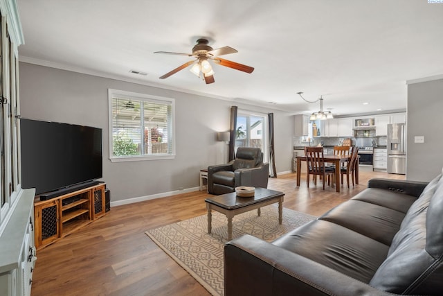 living room with ceiling fan, ornamental molding, baseboards, light wood-style floors, and recessed lighting