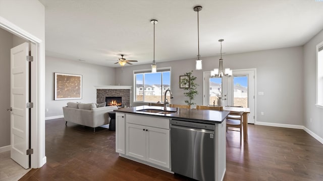 6564 W 38th Ave, Kennewick, WA 99338 - kitchen featuring stainless steel dishwasher, ceiling fan, a stone fireplace, and dark wood-style flooring