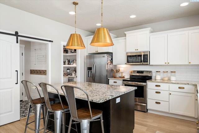 10389 W 17th Pl, Kennewick, WA 99338 - kitchen featuring stainless steel appliances, light wood-style floors, a center island, decorative backsplash, and recessed lighting