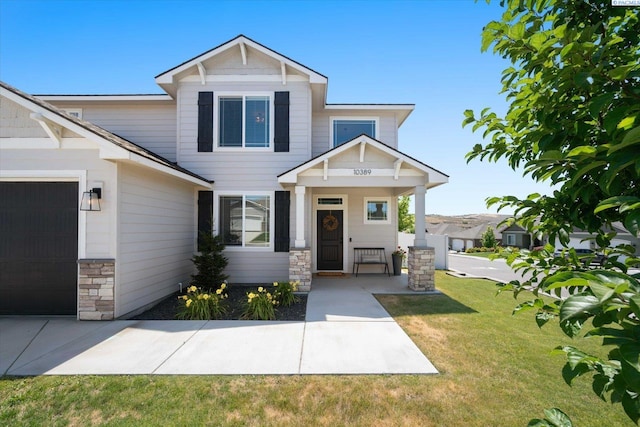 10389 W 17th Pl, Kennewick, WA 99338 - craftsman house featuring a front lawn, an attached garage, and stone siding