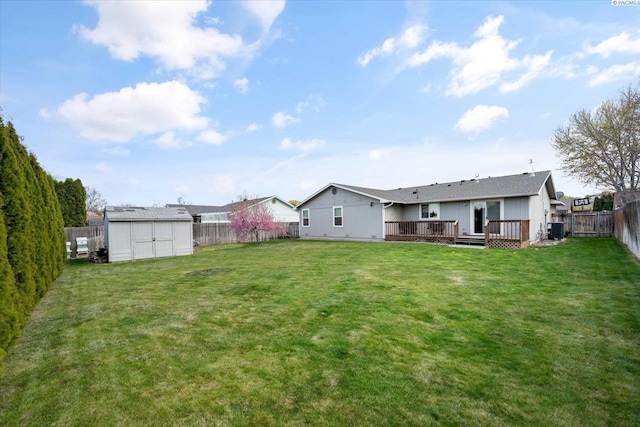 view of yard featuring an outdoor structure, central AC, a wooden deck, a fenced backyard, and a shed