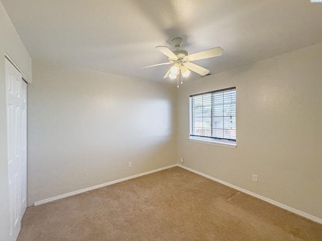 spare room featuring light colored carpet and ceiling fan